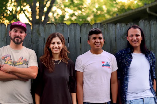 Full band in front of a fence.